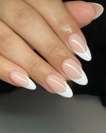 White French tip manicure on almond-shaped nails with a sheer pink base
