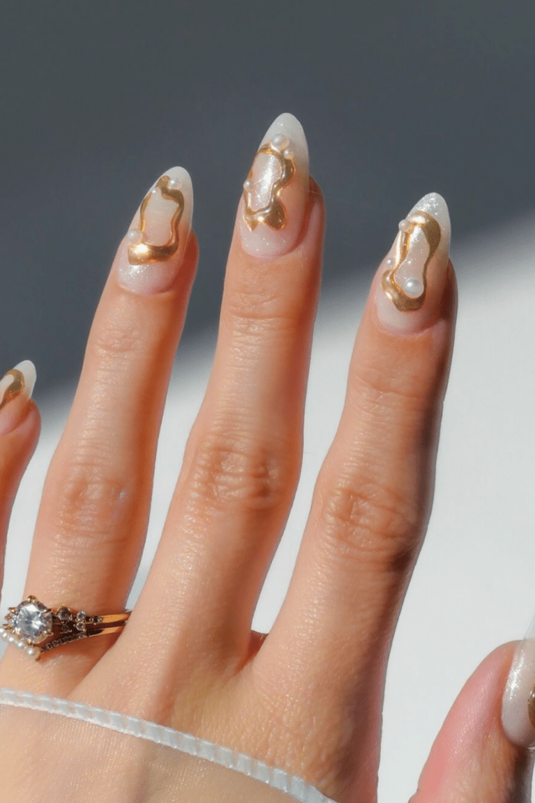 Sheer nude almond nails with abstract gold metallic swirl outlines and tiny pearl dots