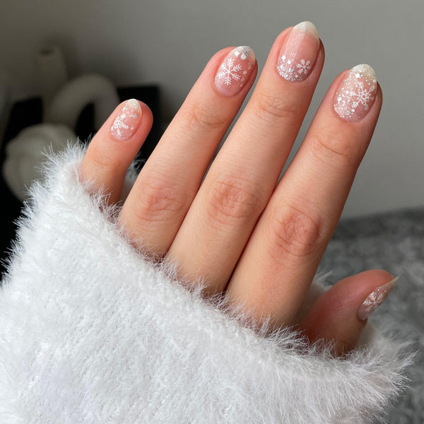 White almond nails with a single delicate snowflake on one nail