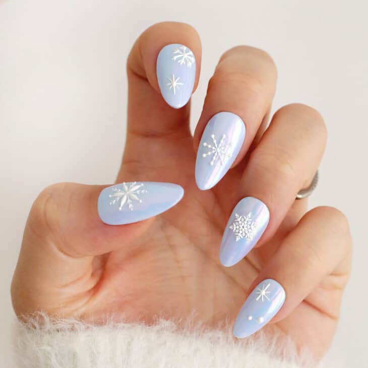 Blue chrome nails with white snowflake nail art