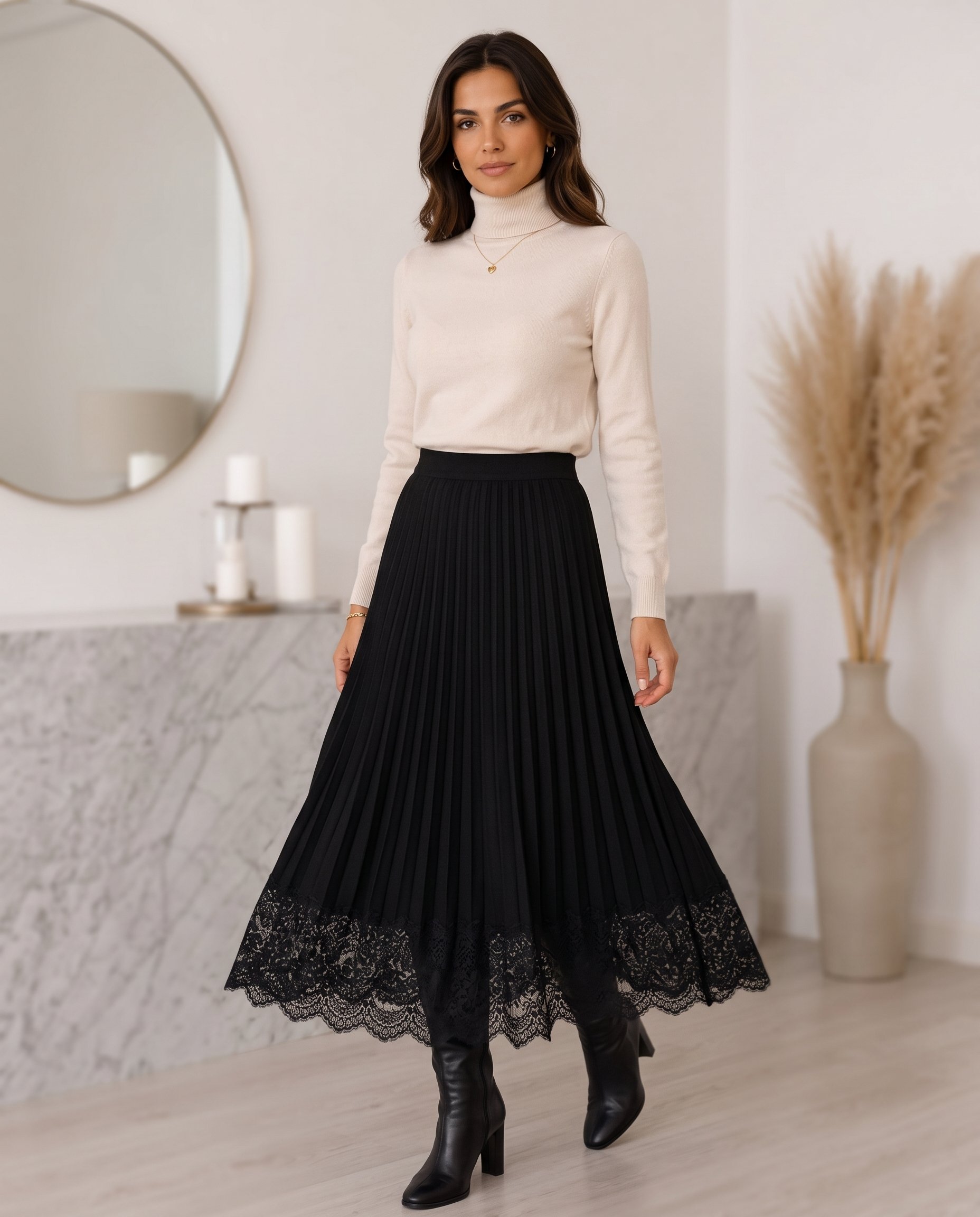 Black knee-high boots with a black pleated midi skirt and cream turtleneck