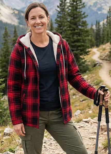 Woman wearing a sherpa-lined plaid flannel jacket on a winter hike