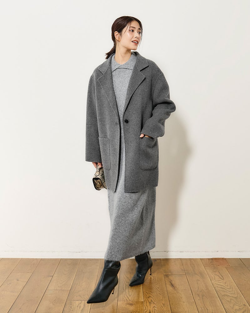 A grey wool coat worn over a grey knit midi dress with black heeled boots