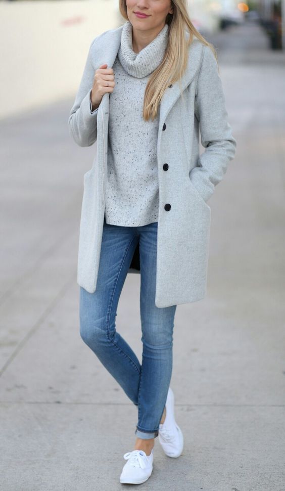Woman in white sneakers, jeans, a sweater and a wool coat